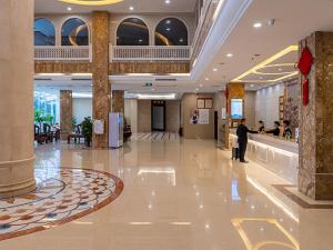 a man standing in a lobby of a building at Vienna Hotel Jingxi Zhongshan Park in Jingxi