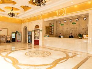 a lobby with two people standing at a counter at Vienna Hotel Foshan Jihua Road in Foshan