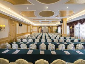 Vienna Hotel Shenzhen Longhua South Renmin Road في باوان: قاعة احتفالات كبيرة فيها كراسي وطاولات