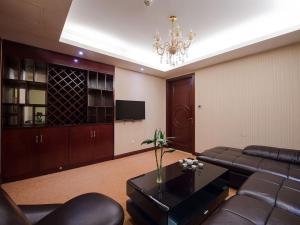 een woonkamer met een bank en een tafel bij Vienna Hotel Shanghai Hongqiao Airport Center in Shanghai