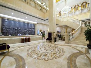 a large lobby with a staircase and a large rug at Vienna Hotel Qinzhou North Area Plaza in Qinzhou