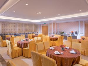 a dining room with tables and yellow chairs at Vienna Hotel Shenzhen Fuyong Subway Station in Bao'an