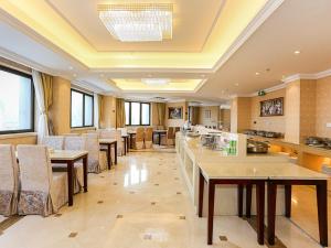 a large room with tables and chairs in a building at Vienna International Hotel Shanghai Fengxian Nanqiao in Fengxian