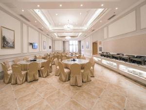 Una gran sala con mesas y sillas. en Vienna Hotel Jiangxi Changxiang Lake, en Lianxi