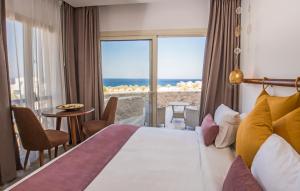 a hotel room with a bed and a view of the ocean at OSKENA Azzurra Sahl Hasheesh Hurghada in Hurghada +37 photos