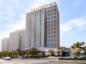 um grande edifício com uma placa no lado em Vienna International Hotel Chong Qing Yu Bei Airport em Chongqing