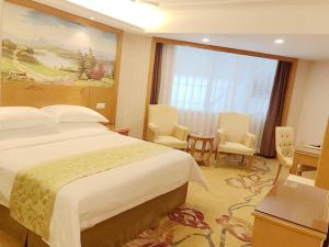 a hotel room with a bed and a table and chairs at Vienna Hotel Shenzhen Dongmen Old Street in Shenzhen