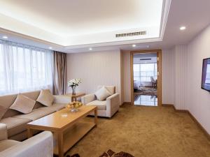 a living room with a couch and a table at Vienna International Hotel Zhongshan Torch Development Zone in Zhongshan