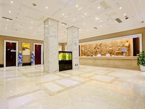 un gran vestíbulo con TV y una pintura en la pared en Vienna Hotel Changsha Gaoxin Lugu Park, en Changsha 4 fotos más
