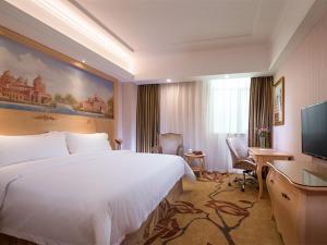 una camera d'albergo con un grande letto e una TV di Vienna Hotel Shenzhen North Science And Technology Park a Shenzhen