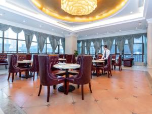 a man sitting at a table in a restaurant at Vienna Hotel Shanghai Songjiang Wanda in Songjiang