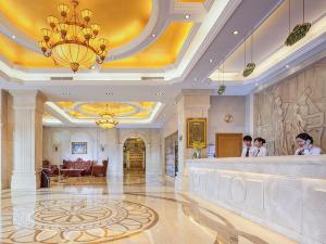 un vestíbulo de un hotel con gente de pie en un bar en Vienna 3 Best Hotel Shenzhen Henggang Cuihu Shangzhuang en Longgang