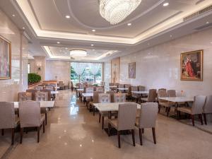 una sala da pranzo con tavoli e sedie in un ristorante di Vienna International Hotel Shenzhen Longhua Center a Bao'an