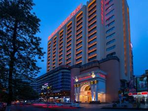 um grande edifício com uma placa no lado em Vienna International Hotel Shaoguan Fengcailou em Shaoguan