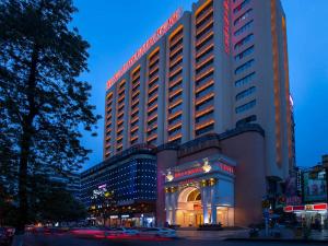 a large building with a sign on the side of it at Vienna International Hotel Shaoguan Fengcailou in Shaoguan