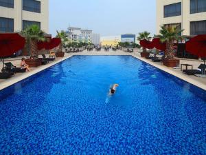 a person swimming in a large blue swimming pool at Vienna Hotel Shenzhen Exibition Center in Shenzhen