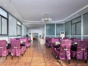 LonggangにあるVienna Hotel Shenzhen Pingshan Shenshan Roadの紫色の椅子とテーブルが備わるレストラン