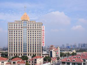 a large building with a tower on top of it at Vienna International Hotel Shanghai Hongqiao Exibition Central Xinqiao in Chunshen