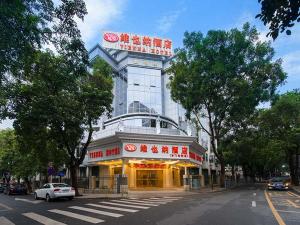 a building with a sign on the side of a street at Vienna Hotel Shenzhen Dongmen Old Street in Shenzhen