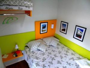 um quarto com uma cama com uma parede laranja e verde em Ecobox Hotel em Três Lagoas