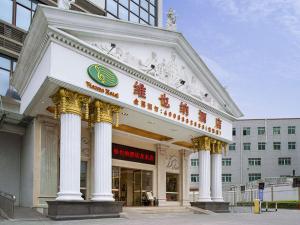 a large building with columns in front of a building at Vienna Hotel Longgang Longdong in Longgang