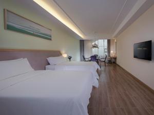 Habitación de hotel con 2 camas y TV de pantalla plana. en Vienna 3 Best Hotel (Guangxi Pubei automobile station store), en Pubei