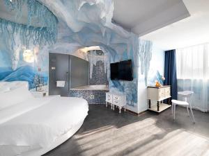 a bedroom with a large bed and a blue wall at Vienna Hotel Shenzhen Exibition Center in Shenzhen