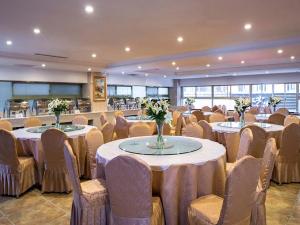 un salón de banquetes con mesas y sillas con flores. en Vienna Hotel Changde Wuling Avenue, en Changde