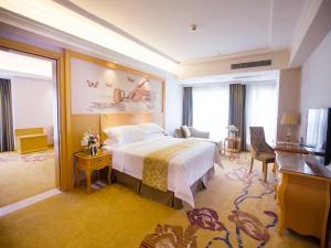 Habitación de hotel con cama y escritorio en Vienna Hotel Guangdong Huizhou Jiangbei Sanxin, en Huizhou