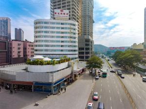 深セン市にあるVienna Hotel Shenzhen Lo Wu Control Pointの車や建物が並ぶ賑やかな街道