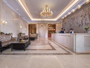 Vienna Hotel (Qionghai Yinhai Road) في Qionghai: لوبي فندق فيه ناس تقف في كونتر