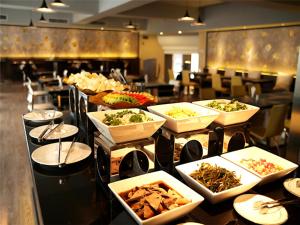 a buffet line with many plates of food in a restaurant at Vienna International Hotel Changzhou Railway Station in Changzhou