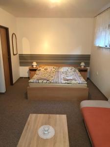 ein Schlafzimmer mit einem Bett und einem Tisch darin in der Unterkunft Privát Magdalena in Bešeňová