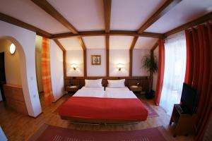 a bedroom with a large bed with a red blanket at Hotel St. Georg in Bad Reichenhall