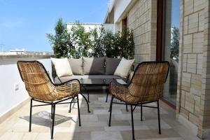 um pátio com 2 cadeiras e um sofá na varanda em Abalto Suites & Rooms em Lecce