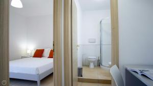 sypialnia z łóżkiem oraz łazienka z toaletą w obiekcie Welcomely - Degli Artigiani - WiFi Vista Bosa w mieście Bosa