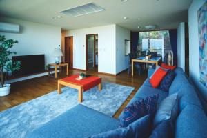戶田的住宿－ゲストハウスジャパン西伊豆/The Guest House Japan Nishi-Izu，客厅配有蓝色的沙发和桌子
