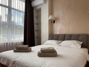 1 dormitorio con 1 cama grande y 2 toallas. en Lustforlive, en Odessa