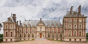 a large building with two towers on a cloudy day at B&B Chateau de Villersexel in Villersexel