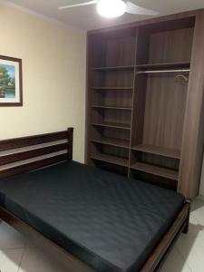 a bedroom with a bed and a book shelf at Casa de Temporada Juquehy in Juquei