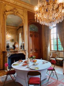 una sala da pranzo con tavolo e lampadario pendente di B&B Chateau de Villersexel a Villersexel