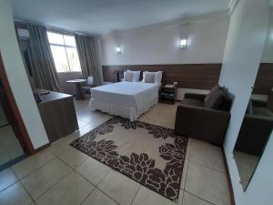 um quarto de hotel com uma cama e um sofá em Hotel del Príncipe em Marabá