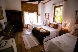 Bichinho的住宿－Pouso do Bichinho 1，一间卧室设有两张床和窗户。