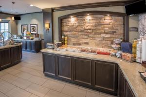 a food counter in a restaurant with a brick wall at Staybridge Suites Columbus-Airport, an IHG Hotel in Columbus