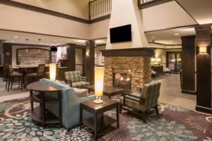 a lobby with a fireplace and chairs and a table at Staybridge Suites Columbus-Airport, an IHG Hotel in Columbus