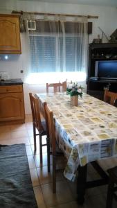 a kitchen with a table with chairs and a table cloth at Casa das Lezírias in Unhais da Serra