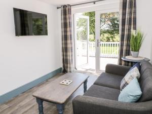 a living room with a couch and a table at The Royal Charter Holiday Let in Moelfre