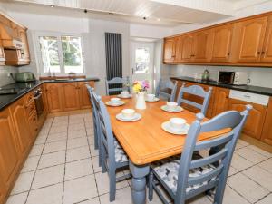 a kitchen with a wooden table and chairs at The Royal Charter Holiday Let in Moelfre