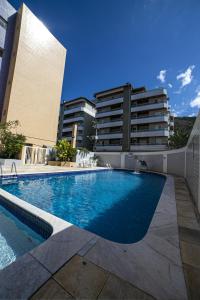 une grande piscine devant un immeuble dans l'établissement Apto 105 - Edifício Imola - Conforto e Segurança para sua família, à Ubatuba