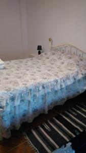 a bed in a room with a blue blanket on it at Casa das Lezírias in Unhais da Serra